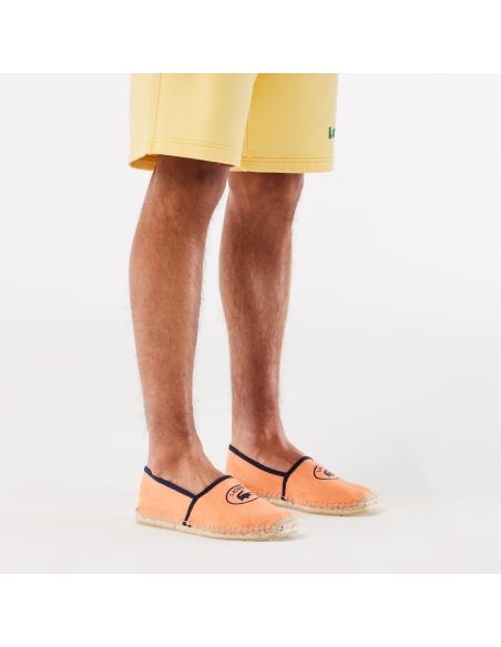 Alpargatas color melocotón con el logo negro de Lacoste.