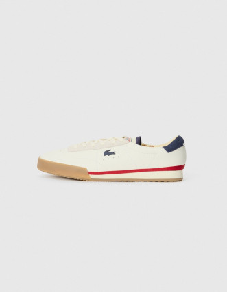 Zapatilla Lacoste blanca con talón rojo.